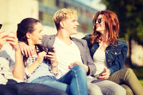 Students looking at smartphones and tablet pc — Stock Photo, Image