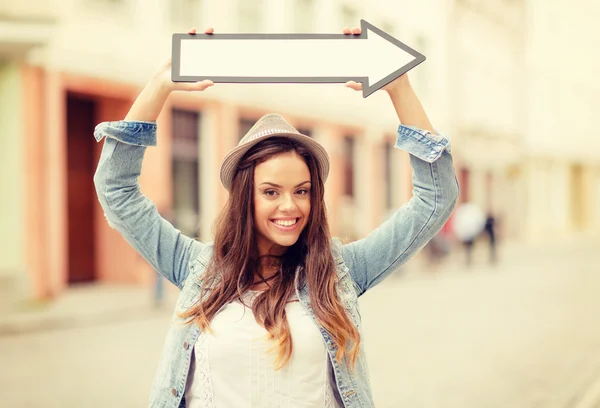 Girl showing direction with arrow in the city — Stock Photo, Image