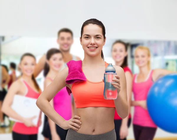 Sportliche Frau mit Handtuch und Wasserflasche — Stockfoto