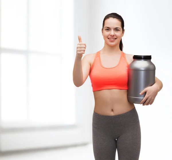 Adolescente con tarro de proteína mostrando los pulgares hacia arriba — Foto de Stock