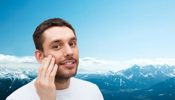 Bellissimo uomo sorridente che si tocca il viso — Foto Stock