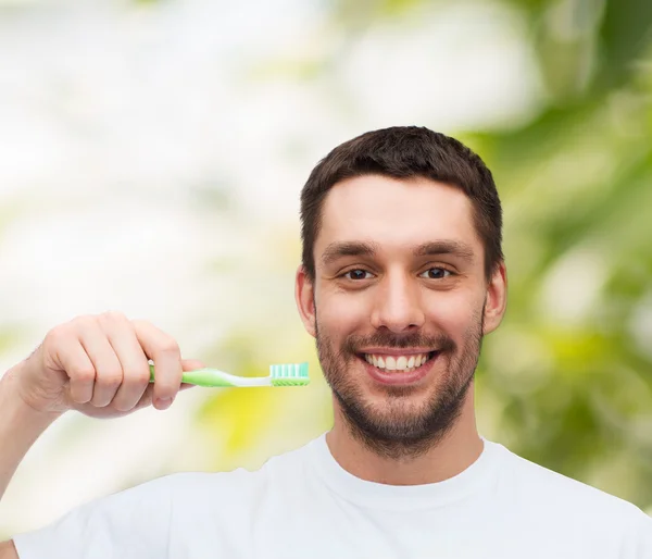 Jeune homme souriant avec brosse à dents — Photo