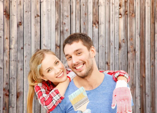 Lächelndes Paar mit Pinsel und Farbe beschmiert — Stockfoto
