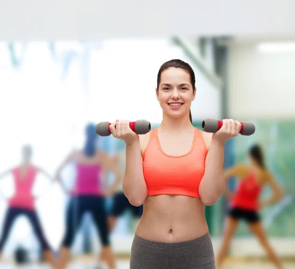 Jovem mulher esportiva com halteres leves — Fotografia de Stock