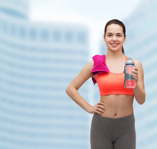 Deportiva mujer con toalla y botella de agua —  Fotos de Stock