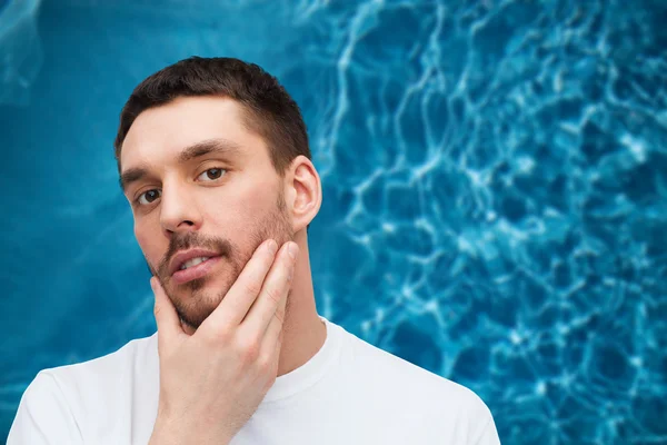 Belo homem calmo tocando seu rosto — Fotografia de Stock