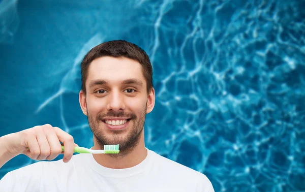 Jeune homme souriant avec brosse à dents — Photo