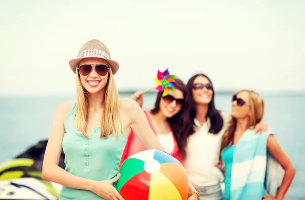 Mädchen mit Ball und Freunden am Strand — Stockfoto