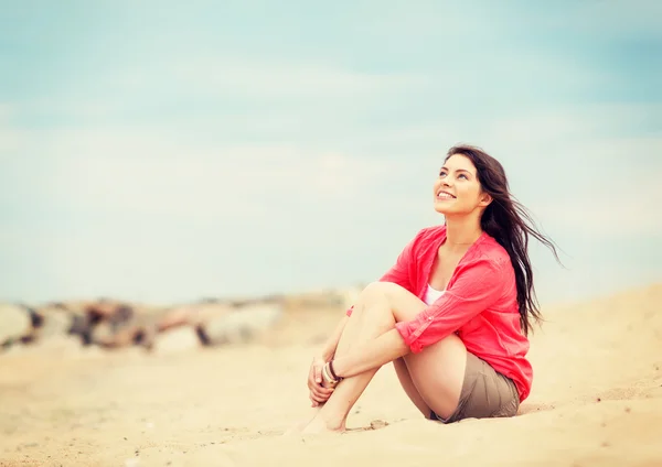 Kız sahilde oturuyor. — Stok fotoğraf