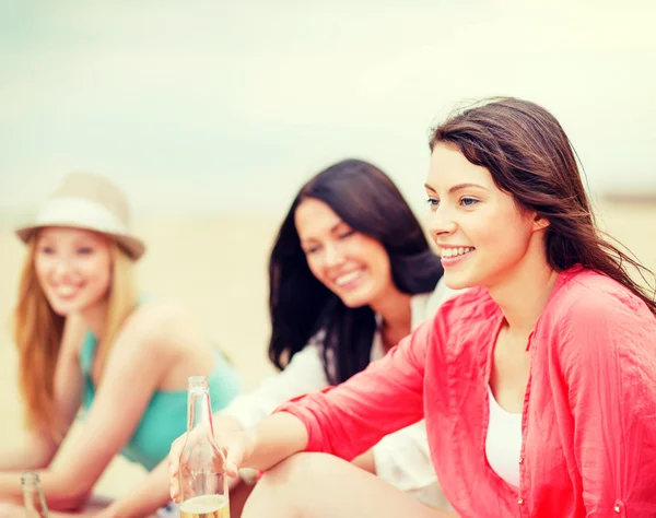Meisjes met dranken op het strand — Stockfoto