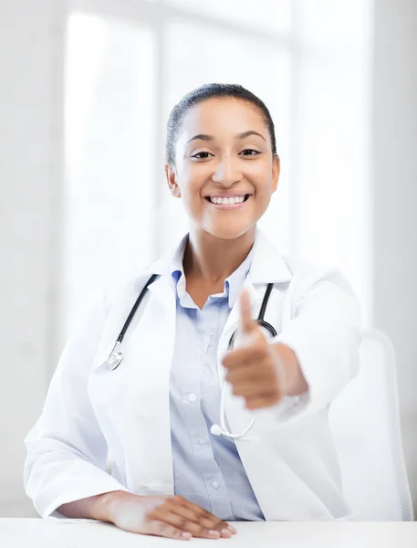 Doktor s stetoskop ukazuje palec — Stock fotografie
