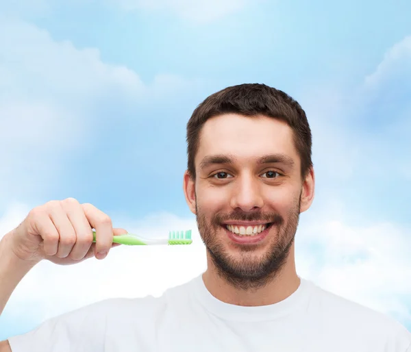 Joven sonriente con cepillo de dientes —  Fotos de Stock