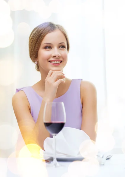 Lächelnde Frau mit einem Glas Wein, die auf ein Date wartet — Stockfoto