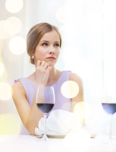 Verärgerte Frau mit Glas Wein beim Warten auf Date — Stockfoto