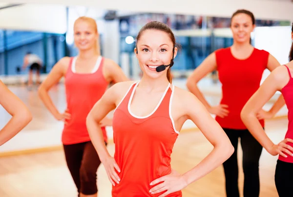 Grupo de pessoas sorrindo se exercitando no ginásio — Fotografia de Stock