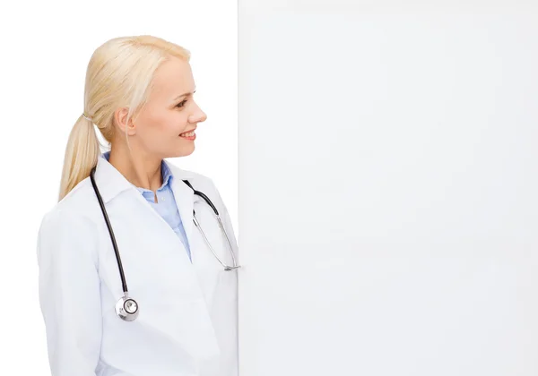 Lachende vrouwelijke arts met wit leeg bord — Stockfoto