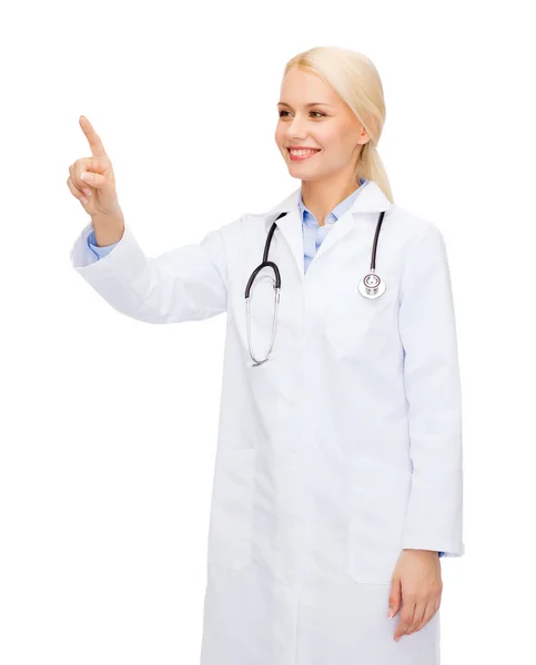 Sorridente medico femminile che indica qualcosa — Foto Stock
