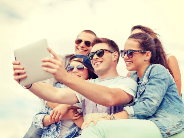 Groep van lachende tieners kijken naar tablet pc — Stockfoto