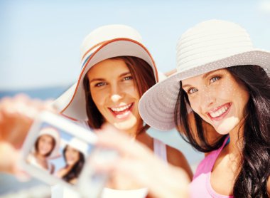 girls taking self portrait on the beach clipart