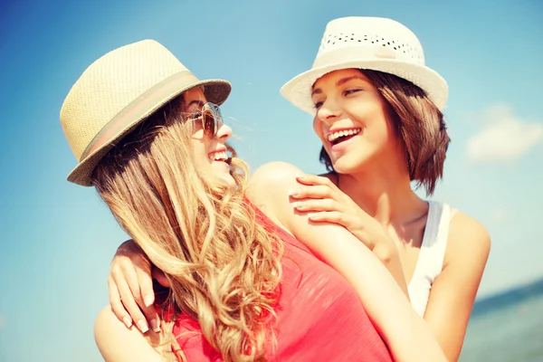 Girls in hats on the beach — Stock Photo, Image
