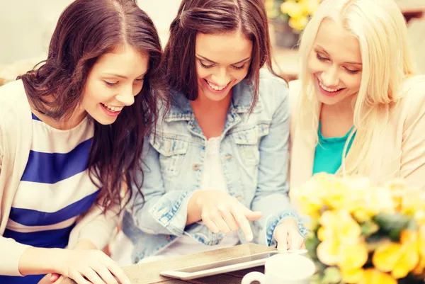Tres hermosas chicas mirando PC tableta en la cafetería — Foto de Stock