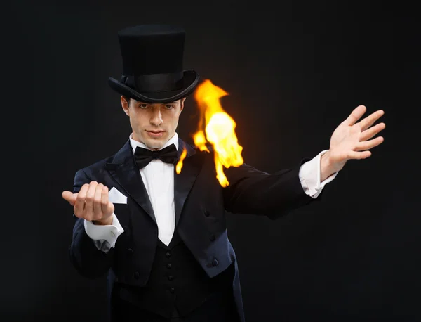 Magician in top hat showing trick with fire — Stock Photo, Image