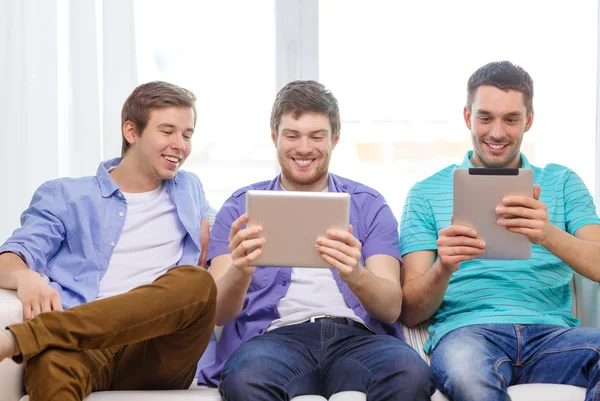 Amici sorridenti con computer tablet pc a casa — Foto Stock