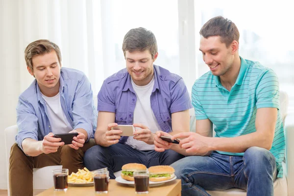 Amigos sorridentes tirando fotos de comida em casa — Fotografia de Stock