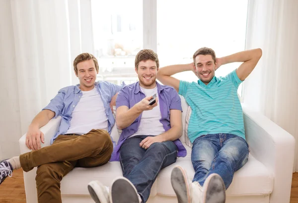 Prieteni zâmbitori cu telecomandă acasă — Fotografie, imagine de stoc