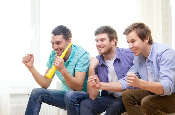 Happy male friends with vuvuzela watching sports — Stock Photo, Image