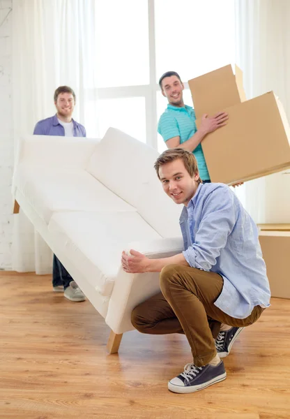 Ler vänner med soffa och lådor på nya hem — Stockfoto