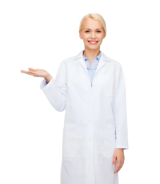 Улыбающаяся женщина-врач держит что-то под рукой — стоковое фото