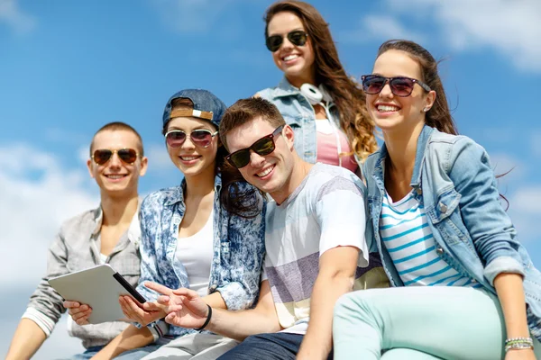 Группа подростков, которые смотрят на планшетный компьютер Стоковое Изображение