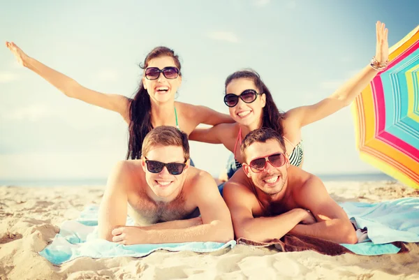 Grupp av leende människor att ha kul på stranden — Stockfoto