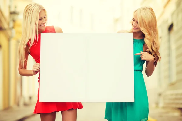 Dos mujeres rubias felices con pizarra blanca en blanco —  Fotos de Stock