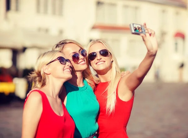 Три красивые девушки фотографируются в городе — стоковое фото