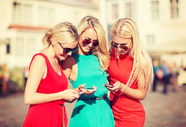 Hermosas chicas con teléfonos inteligentes en la ciudad —  Fotos de Stock