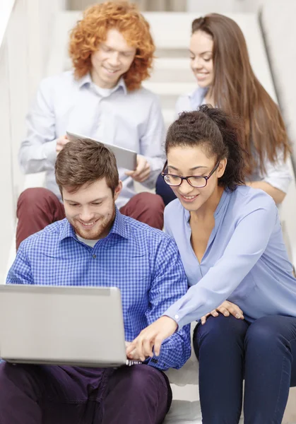 Team med laptop och tablet pc på trappan — Stockfoto