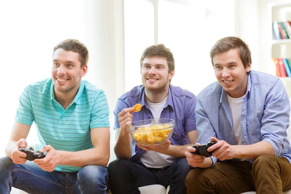 Smiling friends playing video games at home — Stock Photo, Image