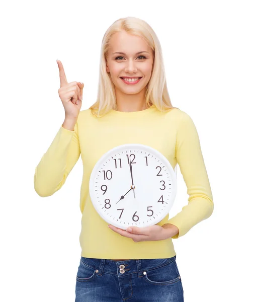 Studente con orologio da parete e dito in su — Foto Stock