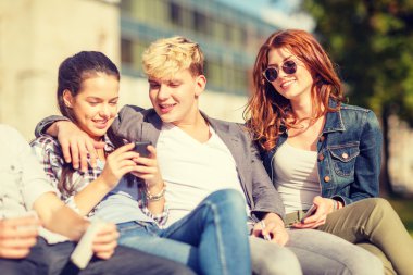 group of students or teenagers with smartphones clipart
