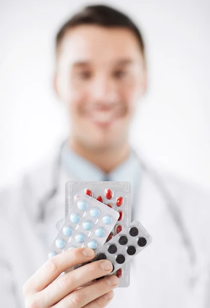 Médico masculino con paquetes de pastillas —  Fotos de Stock