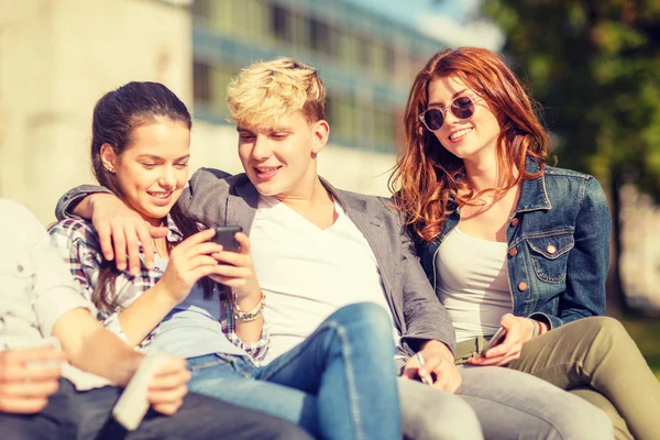 Группа студентов или подростков со смартфонами — стоковое фото