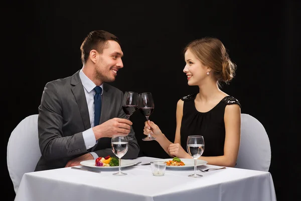 Casal sorrindo comer prato principal no restaurante — Fotografia de Stock