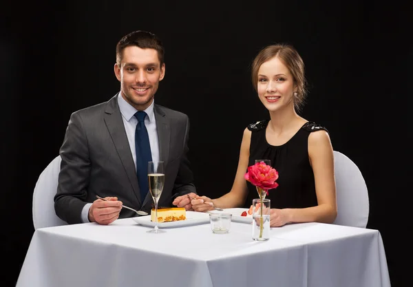 Smiling couple eating dessert at restaurant — Stock Photo, Image