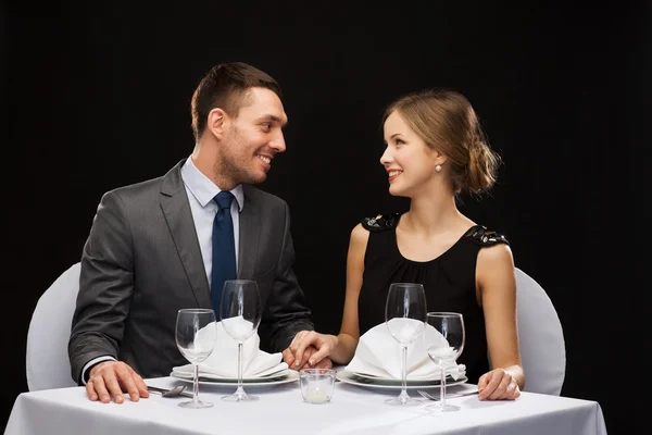 Улыбающаяся пара смотрит друг на друга в ресторане — стоковое фото