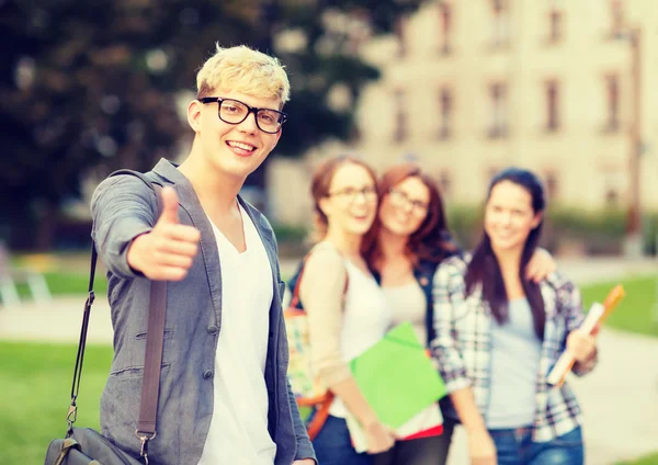 Estudiante masculino con anteojos mostrando pulgares hacia arriba — Foto de Stock