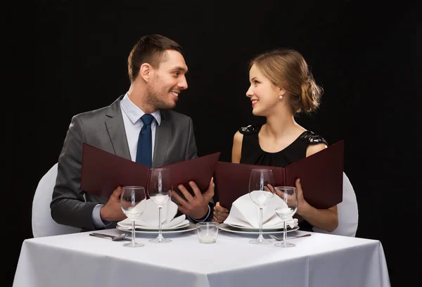 Casal sorrindo com menus no restaurante — Fotografia de Stock