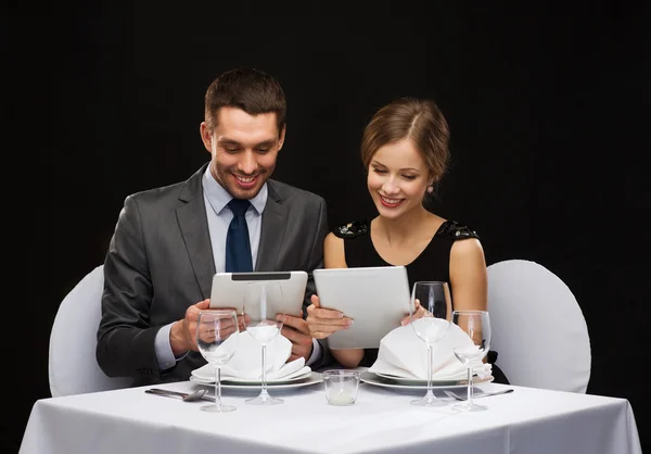 Paar mit Menüs auf Tablet-PC im Restaurant — Stockfoto