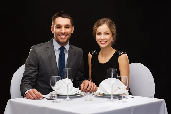 Lachende paar bedrijf handen in restaurant — Stockfoto